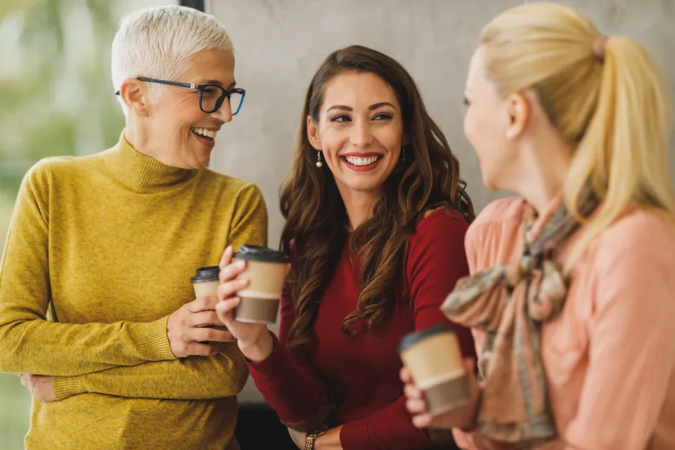 Dos profesionales conversan con café de por medio.