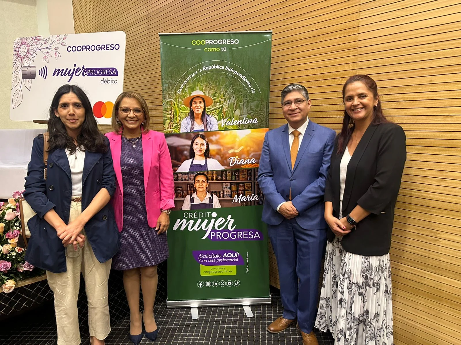 Participantes junto a la señalética de un evento de cooperativas.
